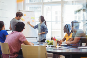 business executives discussing with their colleagues whiteboa scaled