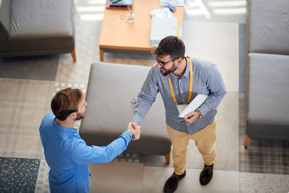 employee with clipboard shaking hands with customer