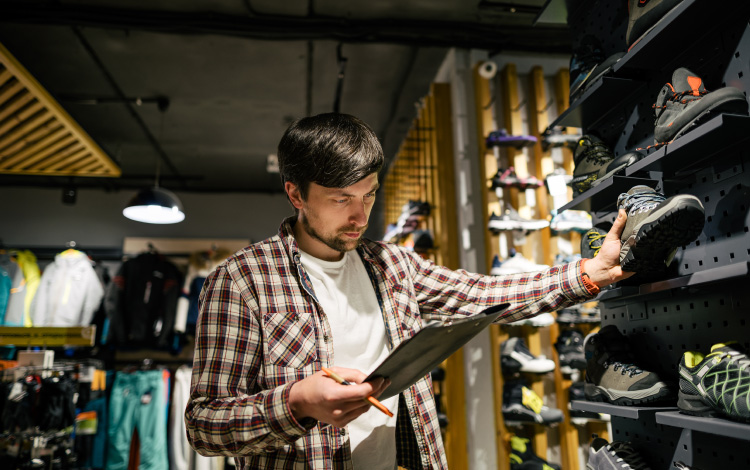 retail worker with clipboard at sporting goods store