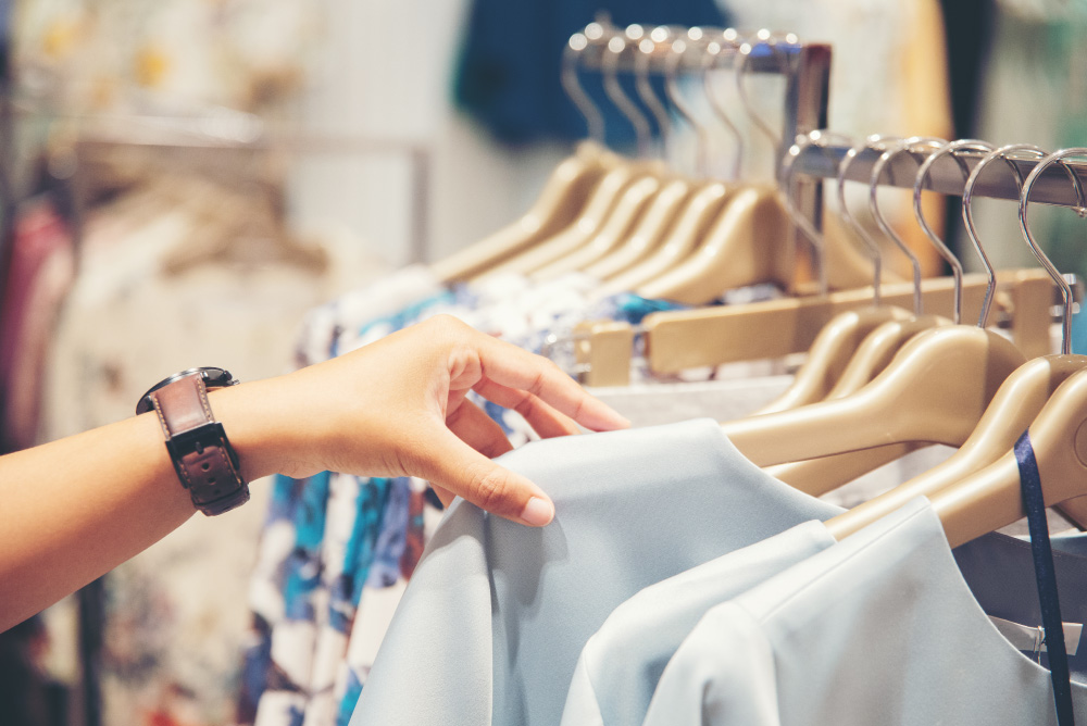 woman shopping through shirt rack