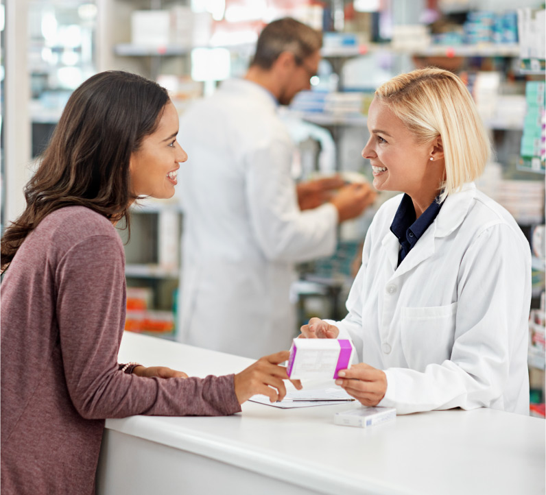 woman picking up medicine at the drugstore counter
